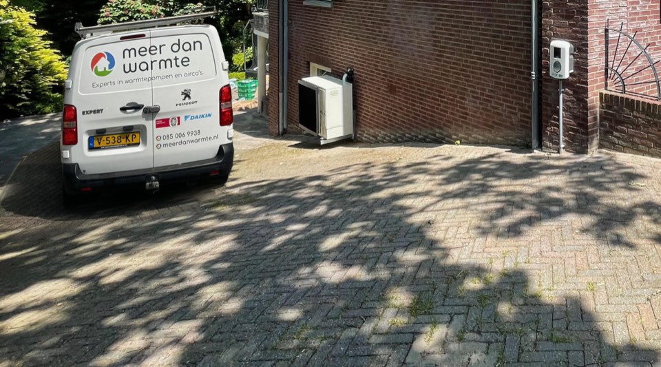 Bedrijfsbus van Meer dan warmte naast een geïnstalleerde Daikin-buitenunit tegen de gevel van een woning